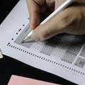 Close up of a person filling out an SAT answer sheet with a pencil